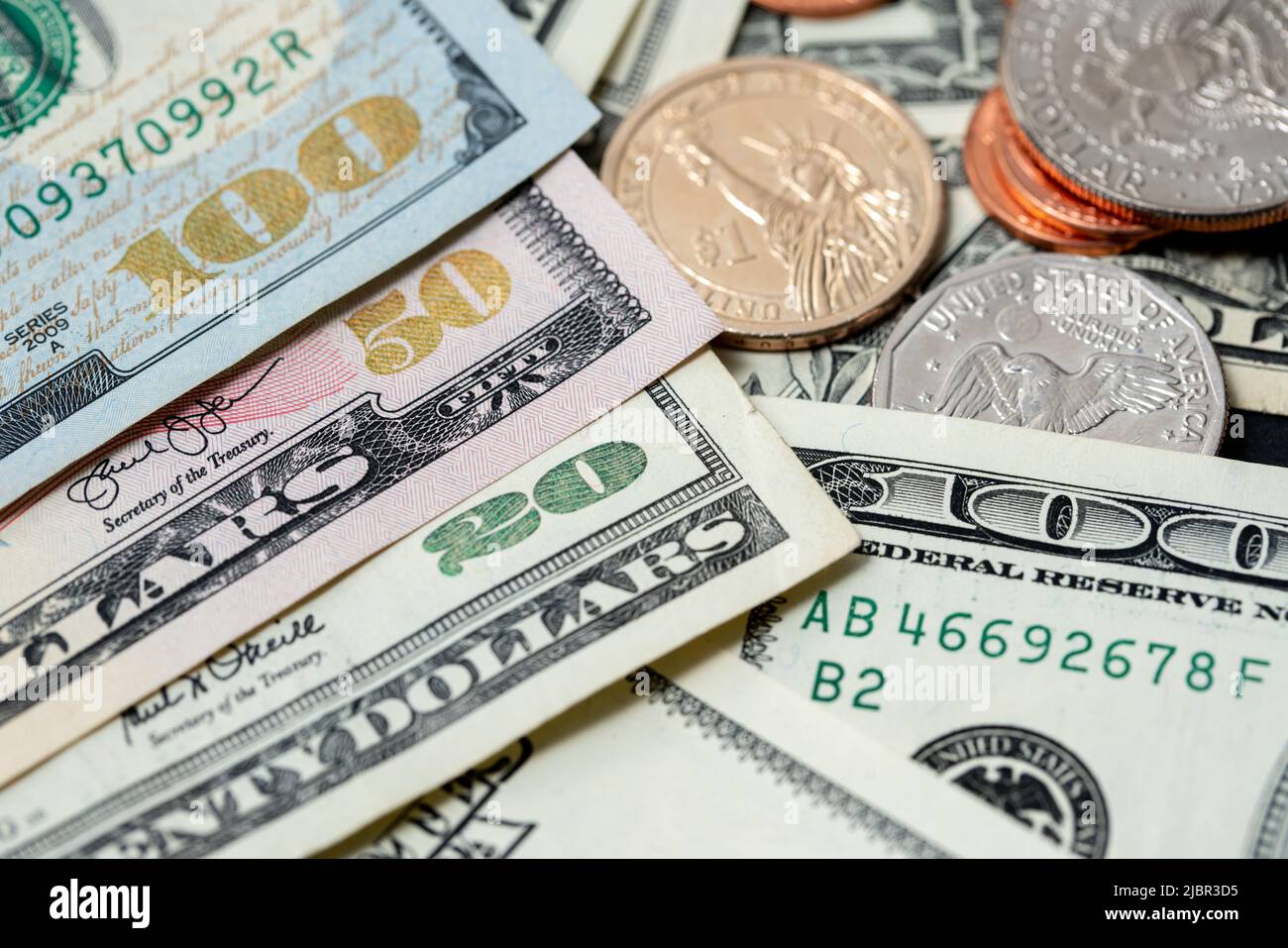 US-Dollar-Banknoten mit glänzenden Stückzahlen, Banknoten neben Dollar-Münzen, 1-Dollar- und Half-Dollar-Münzen Stockfoto