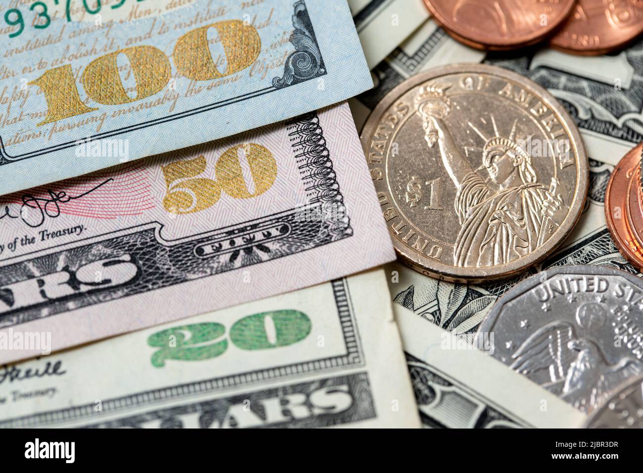 US Dollar Banknoten mit glänzenden Stückzahlen von zwanzig bis hundert USD, Banknoten neben Dollar-Münzen, 1 Dollar-Münze Stockfoto