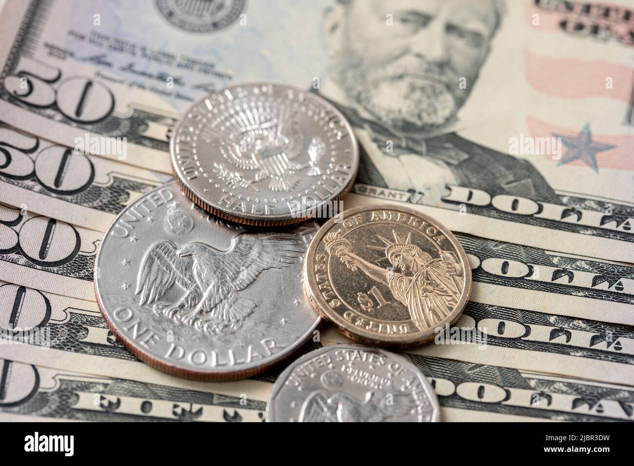 US-Münzen auf 50-Dollar-Banknoten. Eisenhower Dollar und Half Dollar. US-Dollar-Währung. Stockfoto