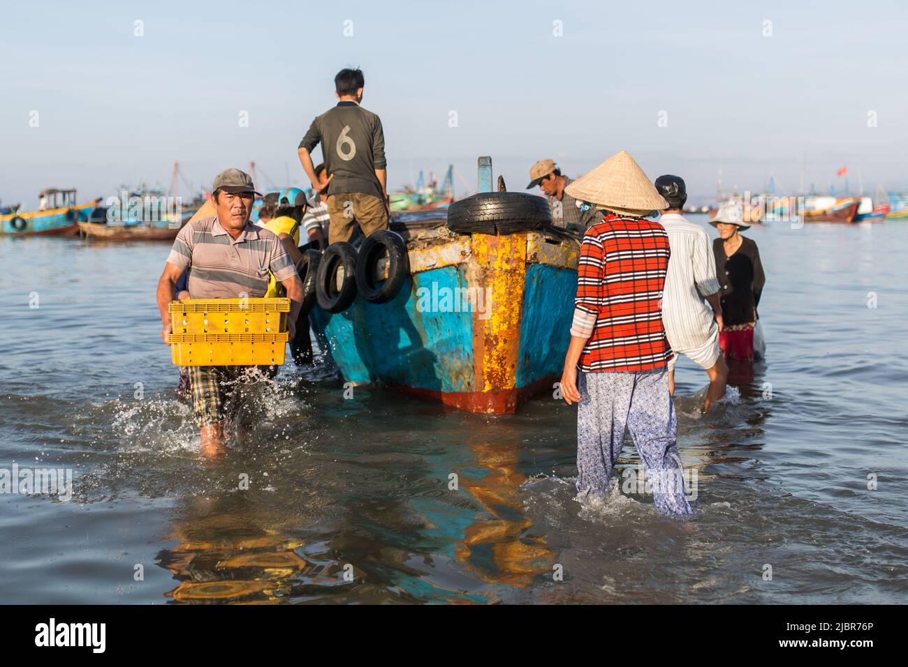 MUI NE, VIETNAM - 9. November 2016: Nicht identifizierte Menschen entladen am Morgen am Strand in Mui Ne am 9. November 2016, Vietnam. Stockfoto