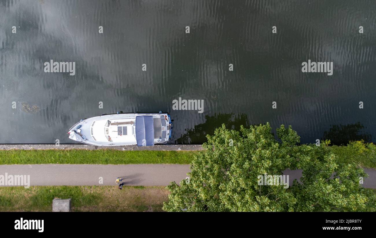 Luftdrohne von oben nach unten Foto einer kleinen Luxusyacht, die am Kai am Flussufer vor Anker liegt. Hochwertige Fotos Stockfoto