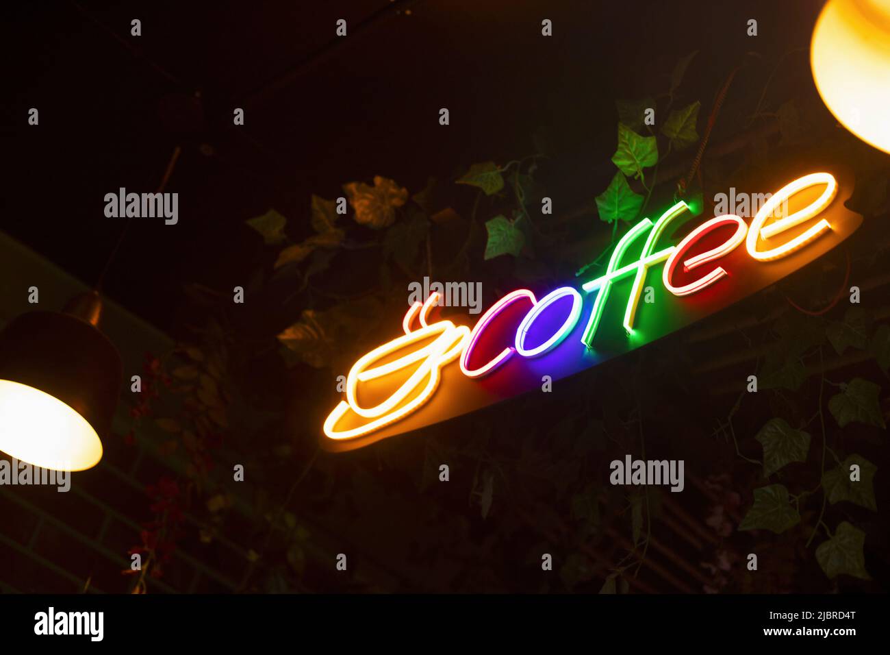 Farbenfrohes Kaffee-Logo, beleuchtet mit Neonlicht Stockfoto