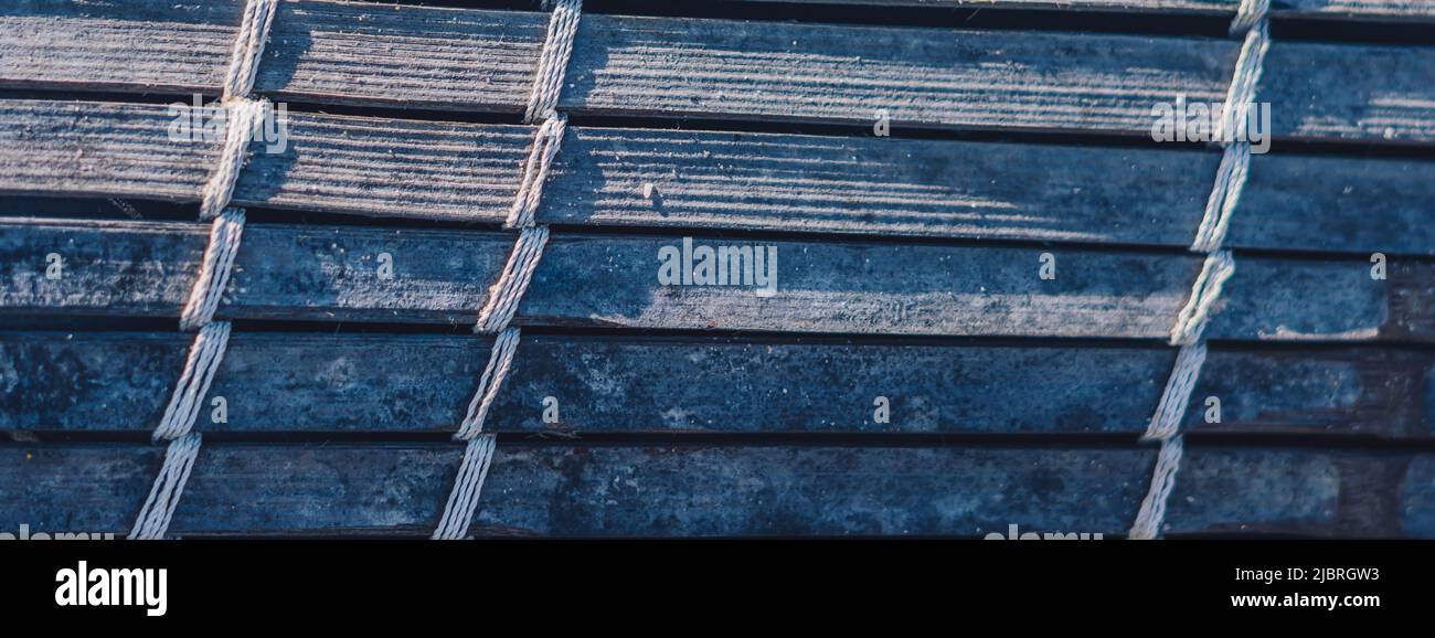 BANNER Alte gewebte Bambusdecke, raue Textur schmutzig, Fragment Banner. Diagonale horizontale vertikale Linien, Kontrastschatten. Platz für Text kopieren. Zusammenfassung Stockfoto