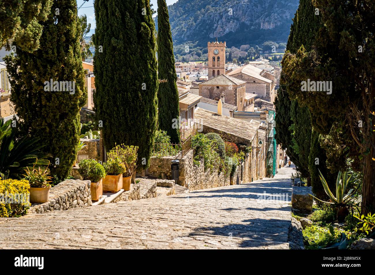 Treppe der Touristenattraktion Calvari Treppe in der Altstadt von Pollença mit Blick über die Dächer auf den Turm der Kirche Santa Maria dels Àngels. Stockfoto