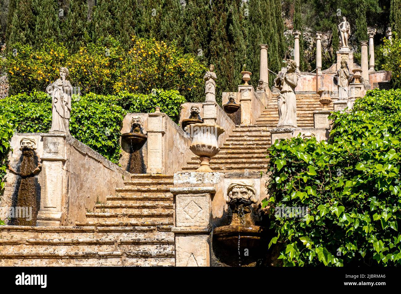 Horizontale Fotografie eines grimmigen Wasserspeiers vor einer alten Treppe mit Skulpturen und Amphoren, genannt Apollo-Treppe mit Statue des gottes Apollo. Stockfoto