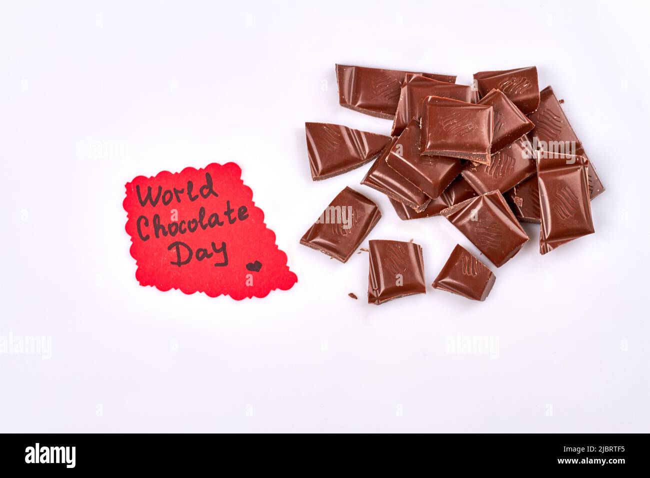 World Chocolate Day Konzept. Haufen dunkler Schokoladenstücke. Isoliert auf weißem Hintergrund. Stockfoto