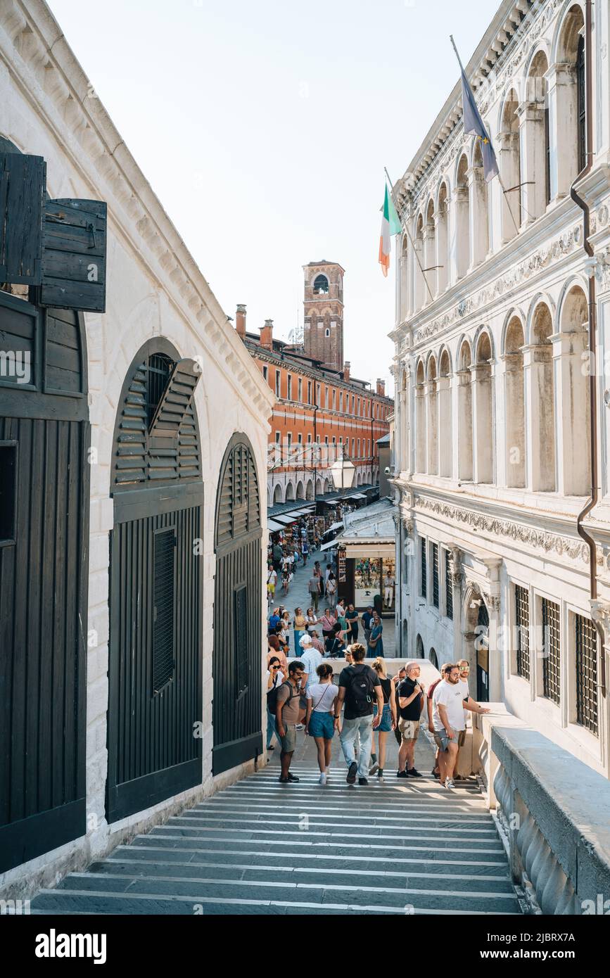 Venedig, Italien - 21. Mai 2022: Menschen gehen auf den Stufen der Rialtobrücke, der ältesten der vier Brücken über den Canal Grande in Venedig. Stockfoto