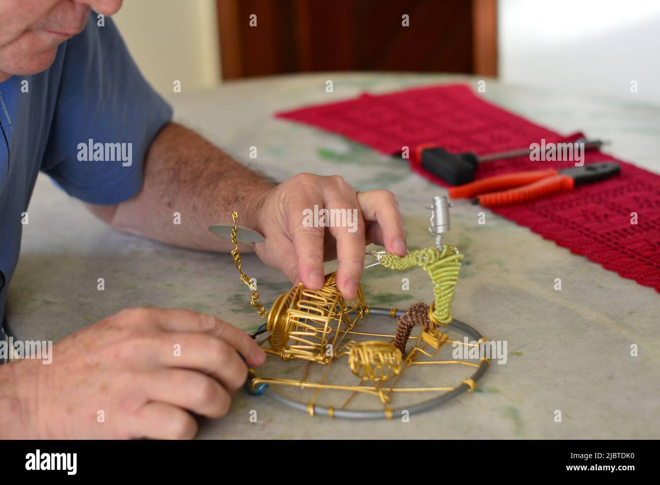 Handarbeit mit Kupferdrähten und mit einigen Instrumenten daneben, auf einem Granittisch, selektiver Fokus. Verschwommener Hintergrund, Brasilien, Südamerika Stockfoto