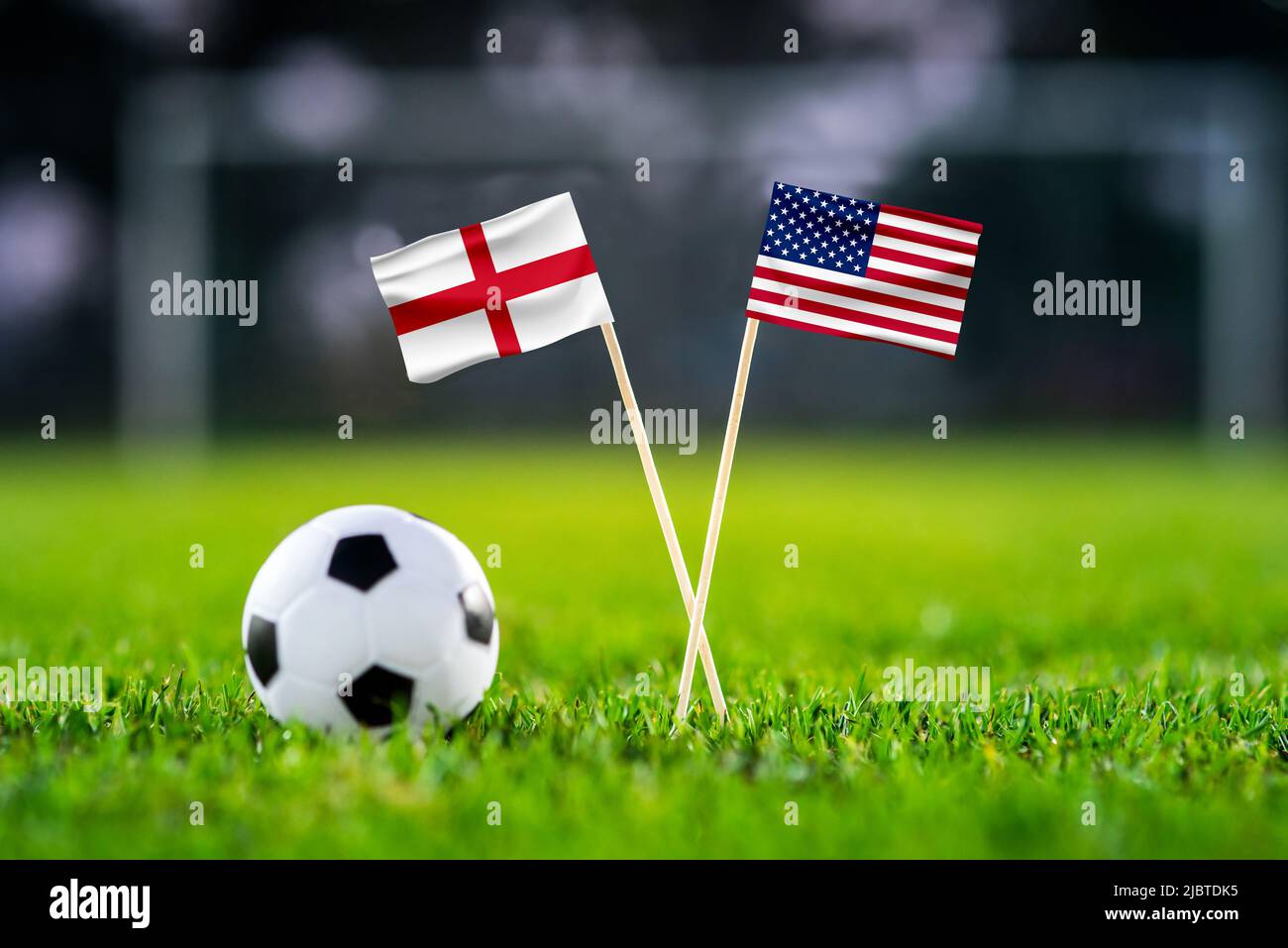 England gegen die Vereinigten Staaten von Amerika, Nationalflaggen auf grünem Gras mit Fußballball. USA und England, Gruppe-B-Fußballspiel in Katar Stockfoto