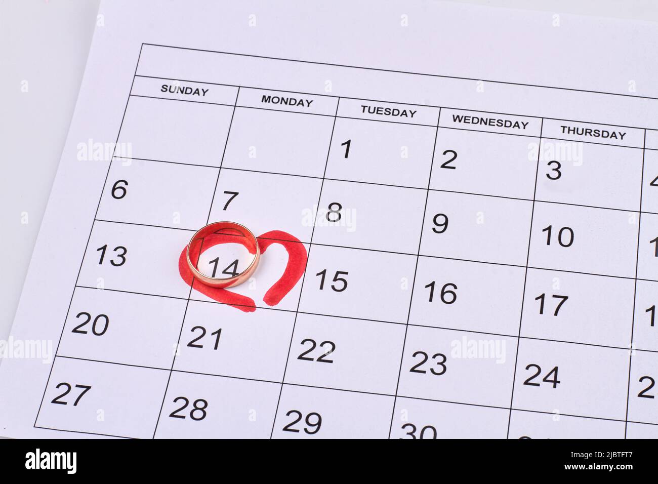 Kalender mit markierter 14. Tage und goldenem Ehering. Draufsicht flach liegend. Stockfoto