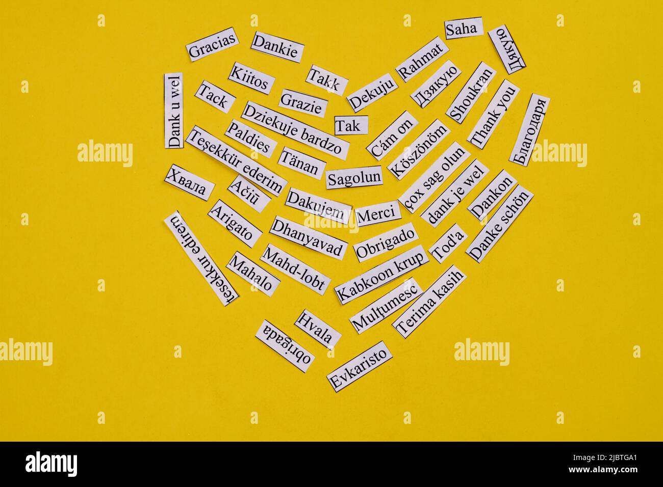 Herz aus vielen Dankesworten in vielen verschiedenen Sprachen. Isoliert auf gelbem Hintergrund. Stockfoto