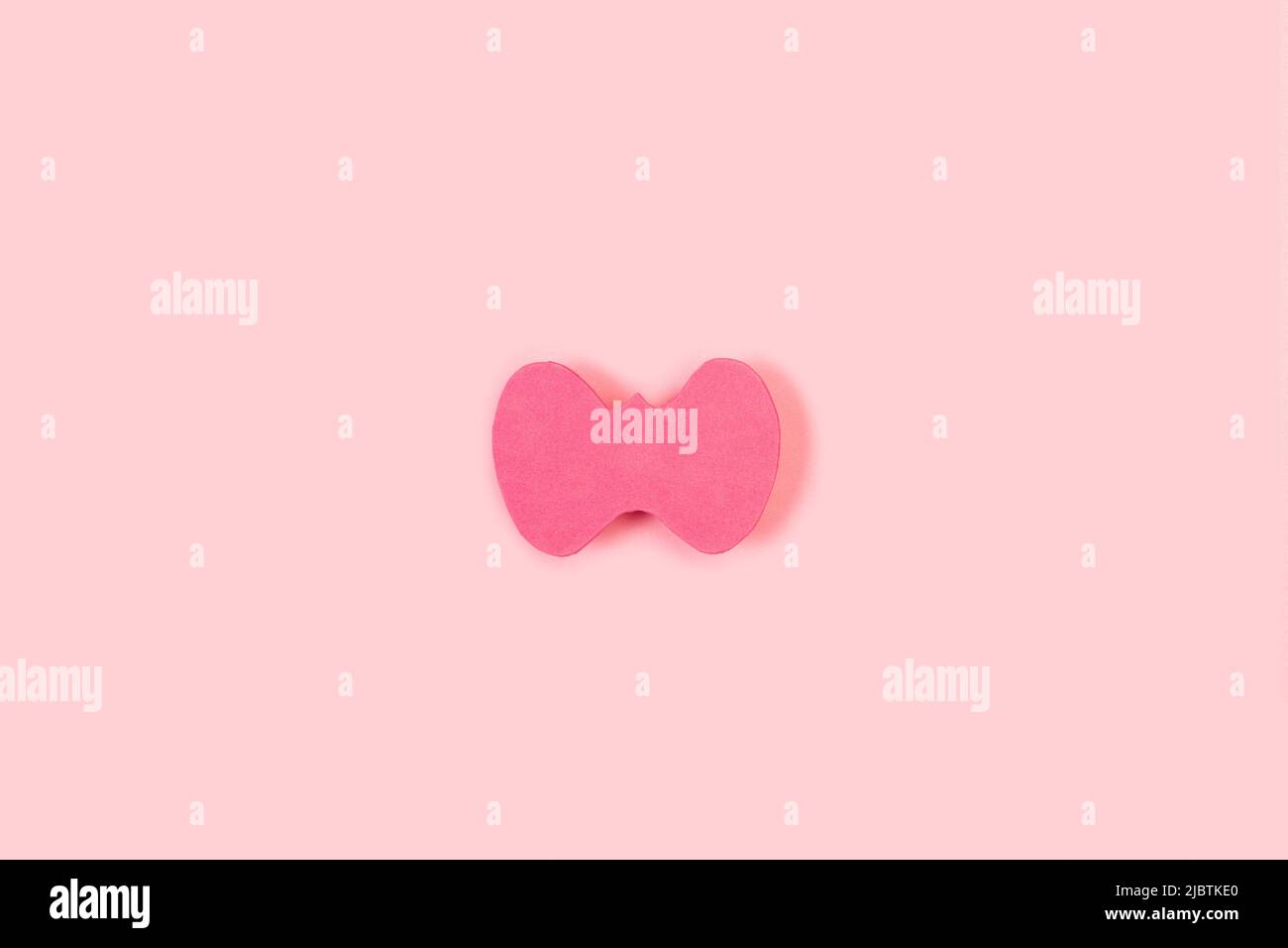 Rosafarbenes Papier in Form einer Schilddrüse auf einem rosa Hintergrund mit Kopierfläche Stockfoto