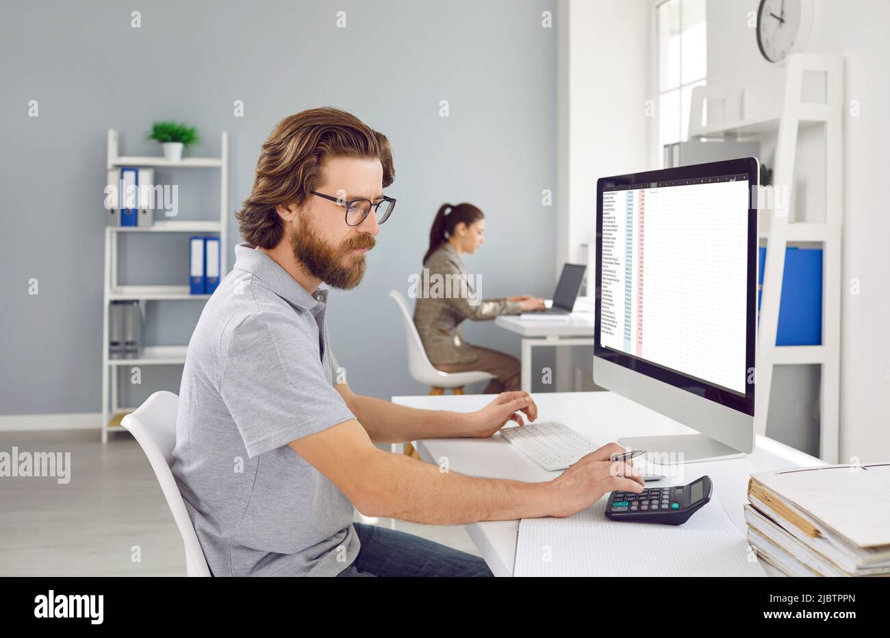 Der männliche Buchhalter verwendet Rechner und Software auf dem Laptop, um das Finanzprojekt der Buchhaltung zu analysieren. Stockfoto