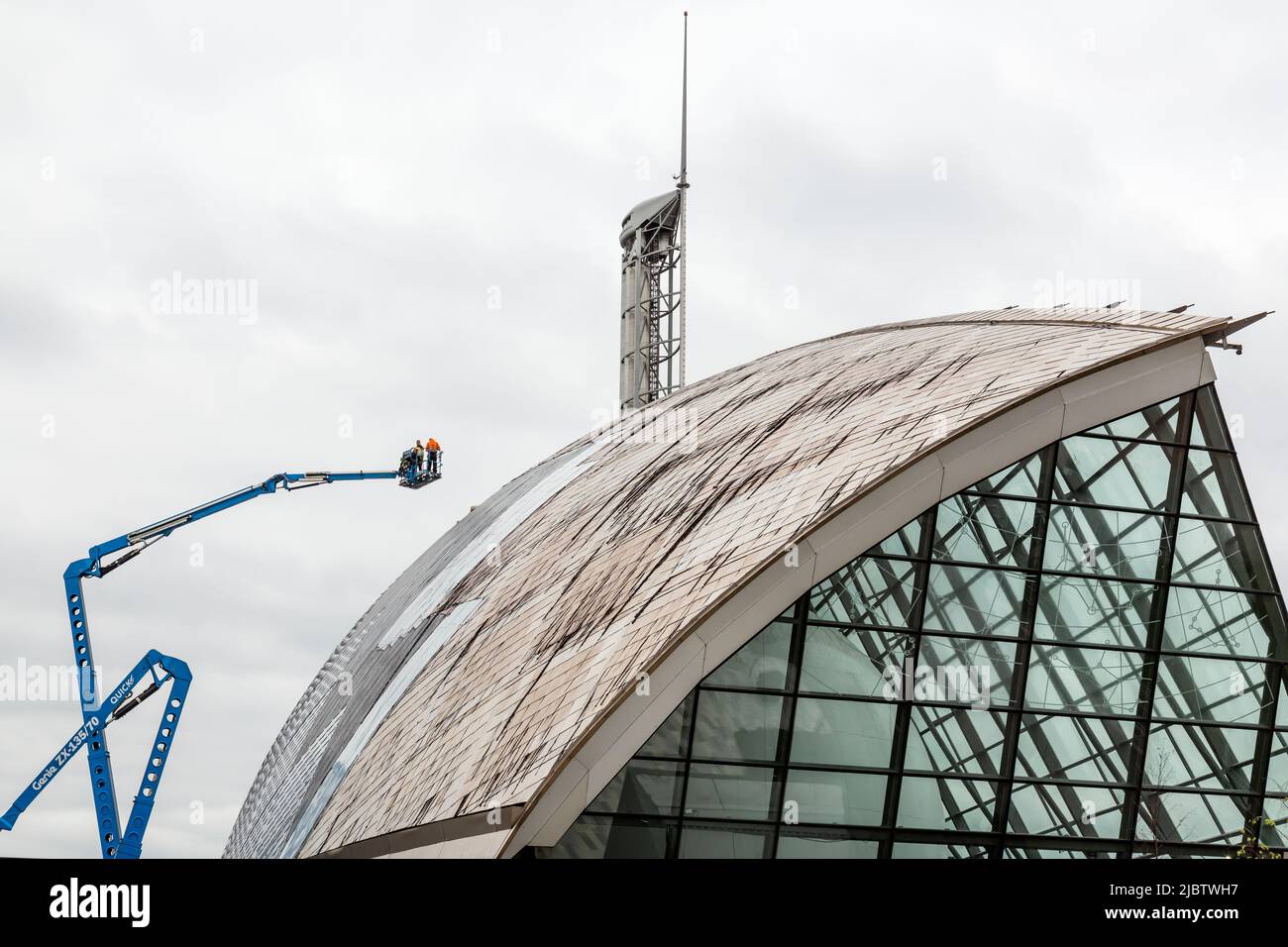 Arbeiter auf einer hydraulischen Hebebühne, die das beschädigte Dach im Glasgow Science Centre, Pacific Quay, Schottland, Großbritannien, Europa reparieren Stockfoto