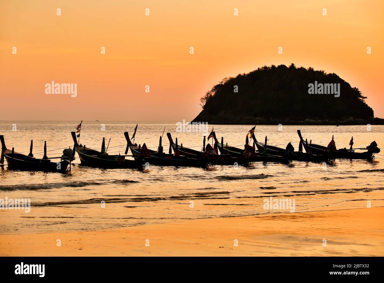 Longtail-Boote bei Sonnenuntergang am Kata Beach auf der Insel Phuket in der Provinz Phuket, Thailand. Stockfoto