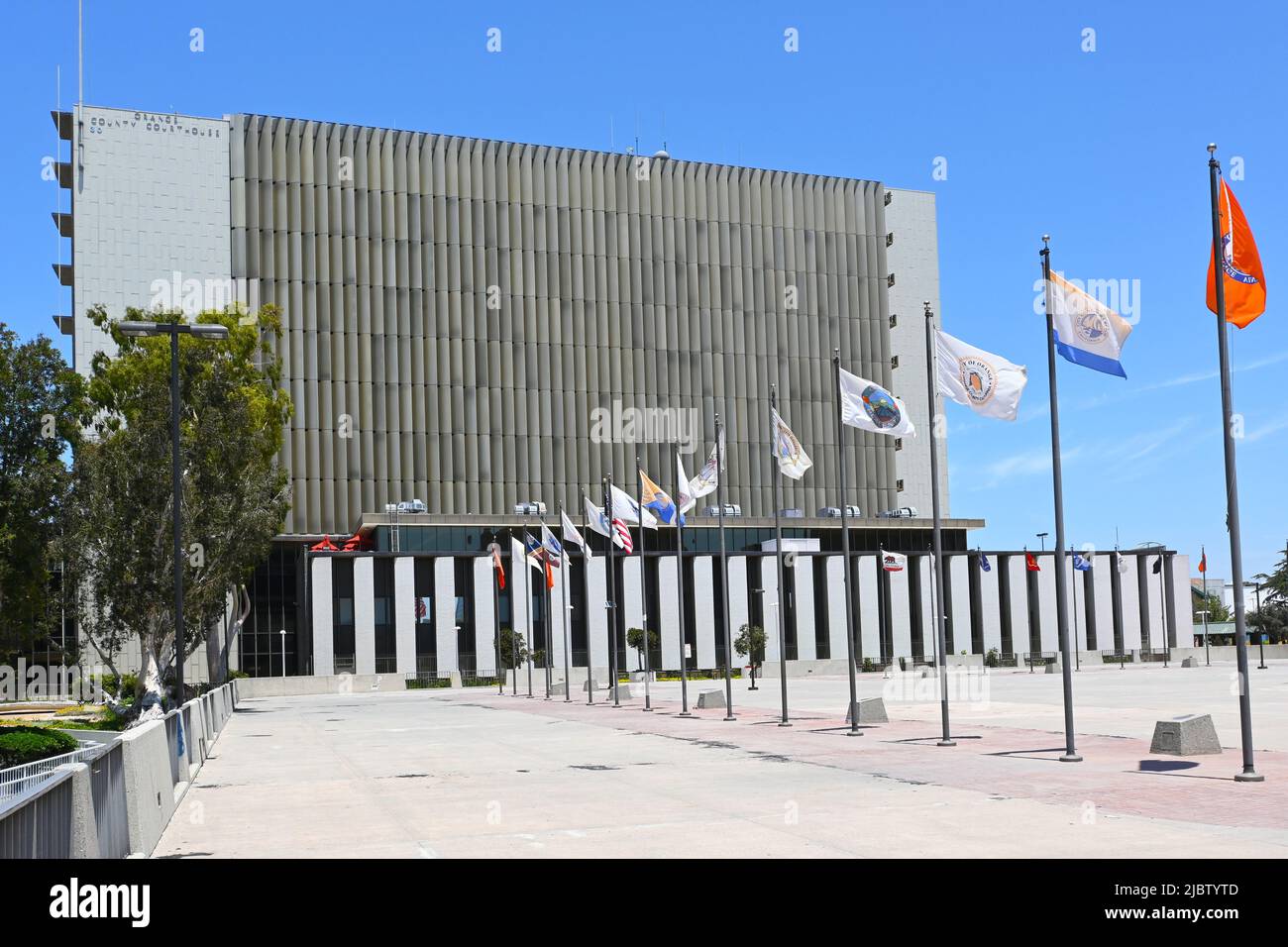 SANTA ANA, KALIFORNIEN - 2. JUNI 2022: Das Orange County Courthouse und die Stadtflaggen im Civic Center Plaza. Stockfoto