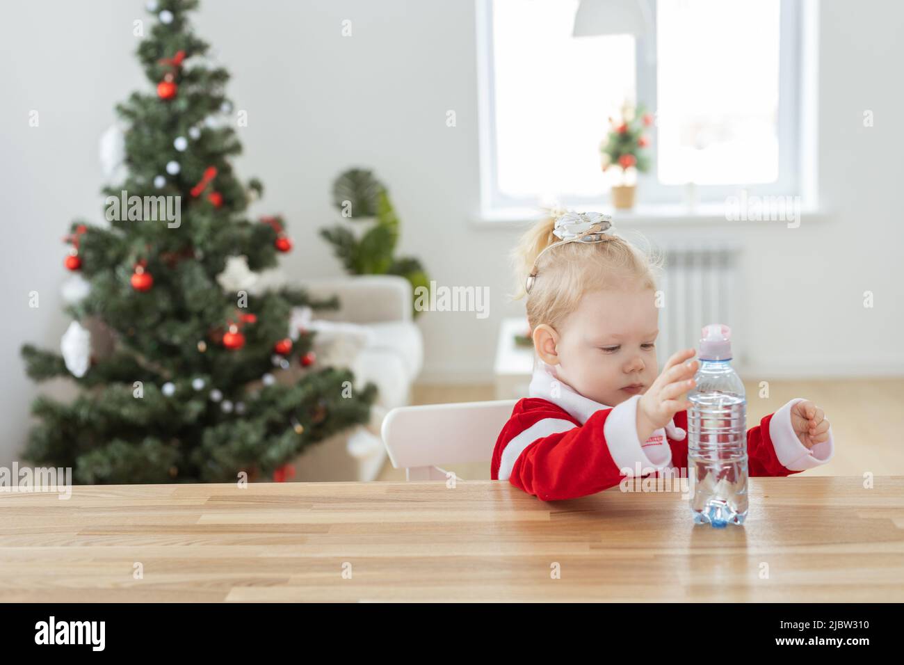 Kindermädchen in weihnachtskleid mit Cochlea-Implantaten gekleidet Spaß zu Hause - Vielfalt und Hörgeräte und innovative Technologien für die Behandlung Stockfoto