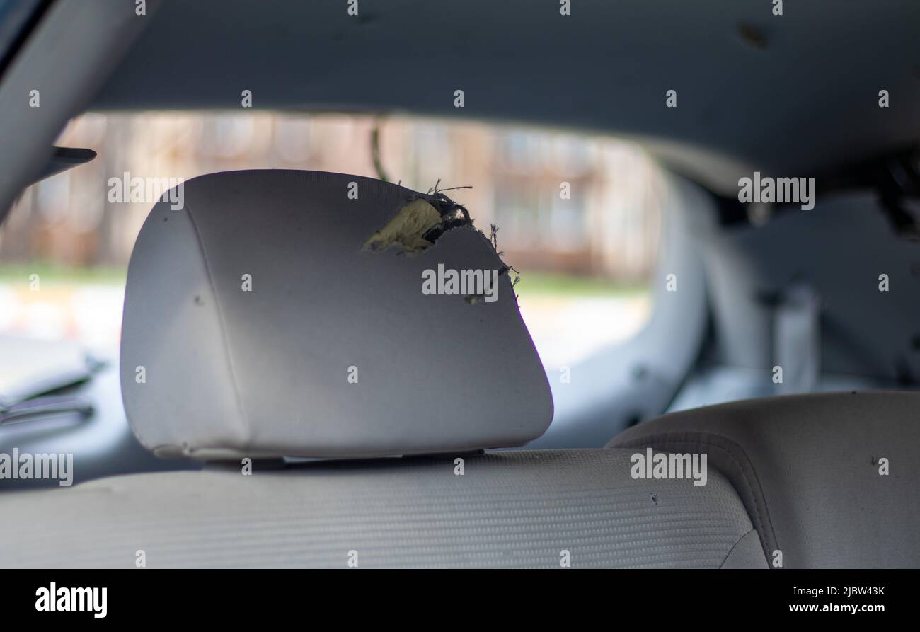 Der Innenraum des Fahrzeugs ist nach dem Unfall beschädigt, zerbrochenes Glas auf dem Sitz. Beschädigter Innenraum Stockfoto