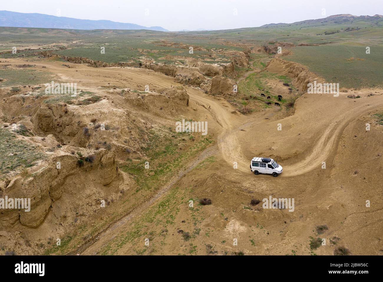 Luftviev des Vierradantriebs, der auf einer unbefestigten Straße in einer kleinen Schlucht auf dem Weg von Dedoplas Tskaro nach Takhti-TEPHA Mud Volcanoes, Georgia, fährt Stockfoto