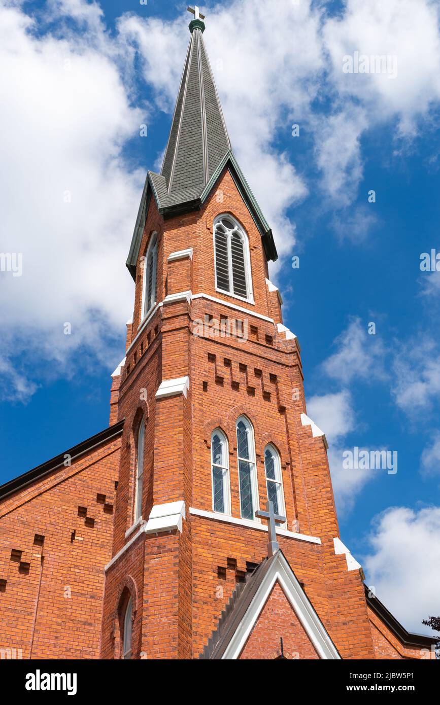 Wunderschöne Backsteinkirche in einer kleinen Stadt im Mittleren Westen mit blauem Himmel und Wolken im Hintergrund. Stockfoto