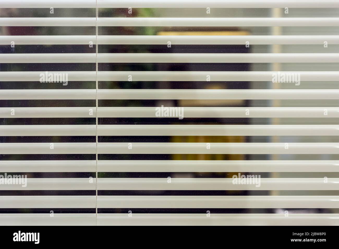 Weiße Bürojalousien decken die Glaswand im Raum ab. Für den Einsatz als Hintergrund. Stockfoto