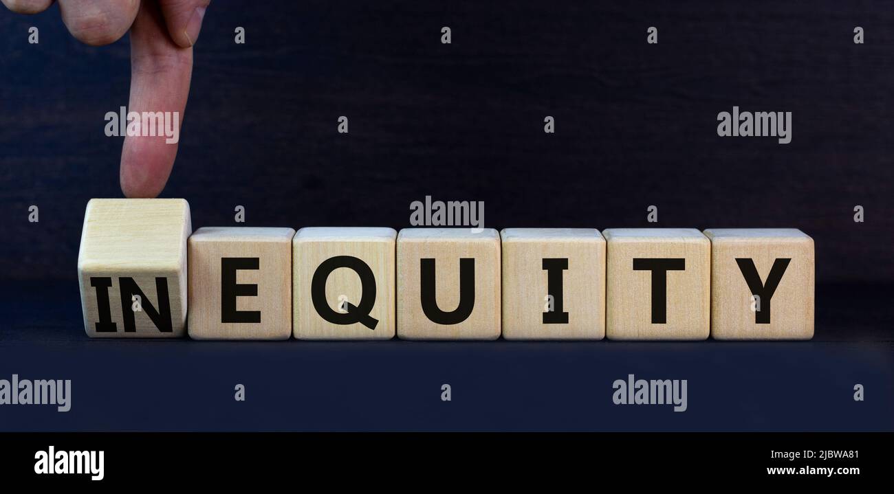 Symbol für Ungleichheit oder Eigenkapital. Drehten Holzwürfel und änderten das Konzeptwort InEquity in Equity. Schöne graue Tabelle grauen Hintergrund. Business und ine Stockfoto