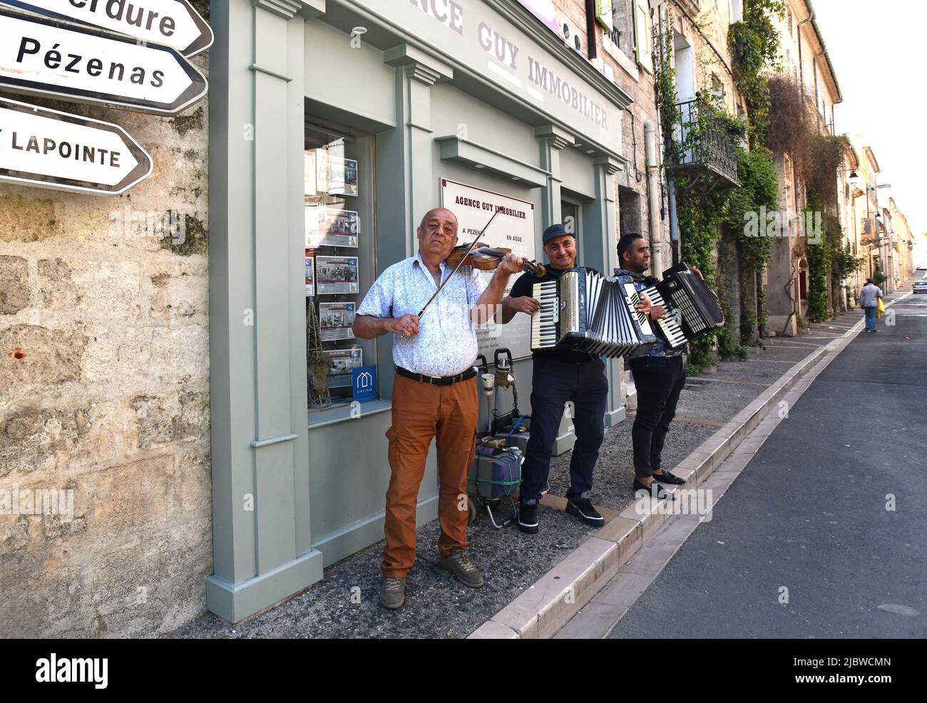 Männer, die an der Straßenecke in Pezenas, Frankreich, unterwegs sind Stockfoto