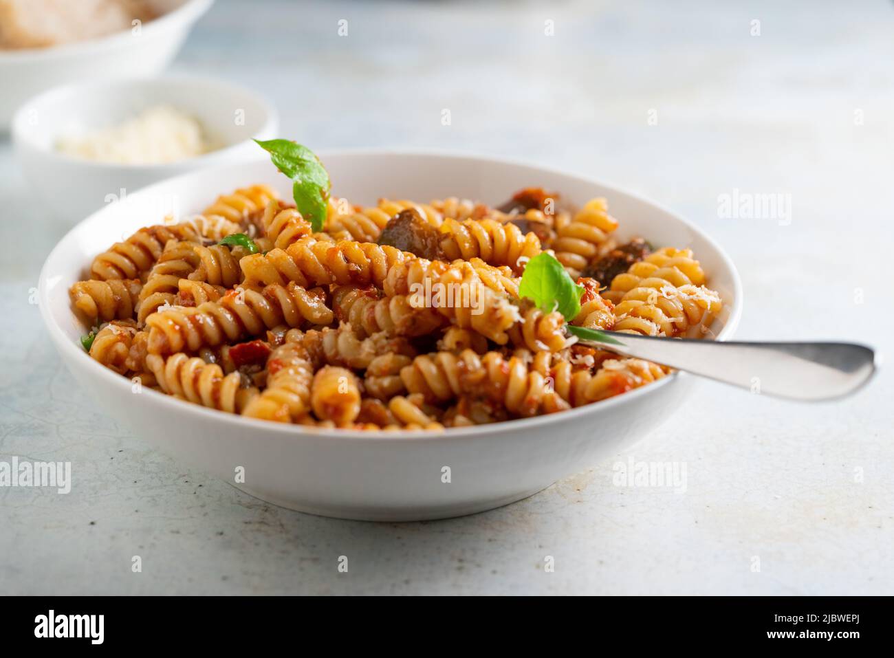 Pasta alla Norma - Traditionelle italienische Küche mit Auberginen, Tomaten, Käse und Basilikum Stockfoto