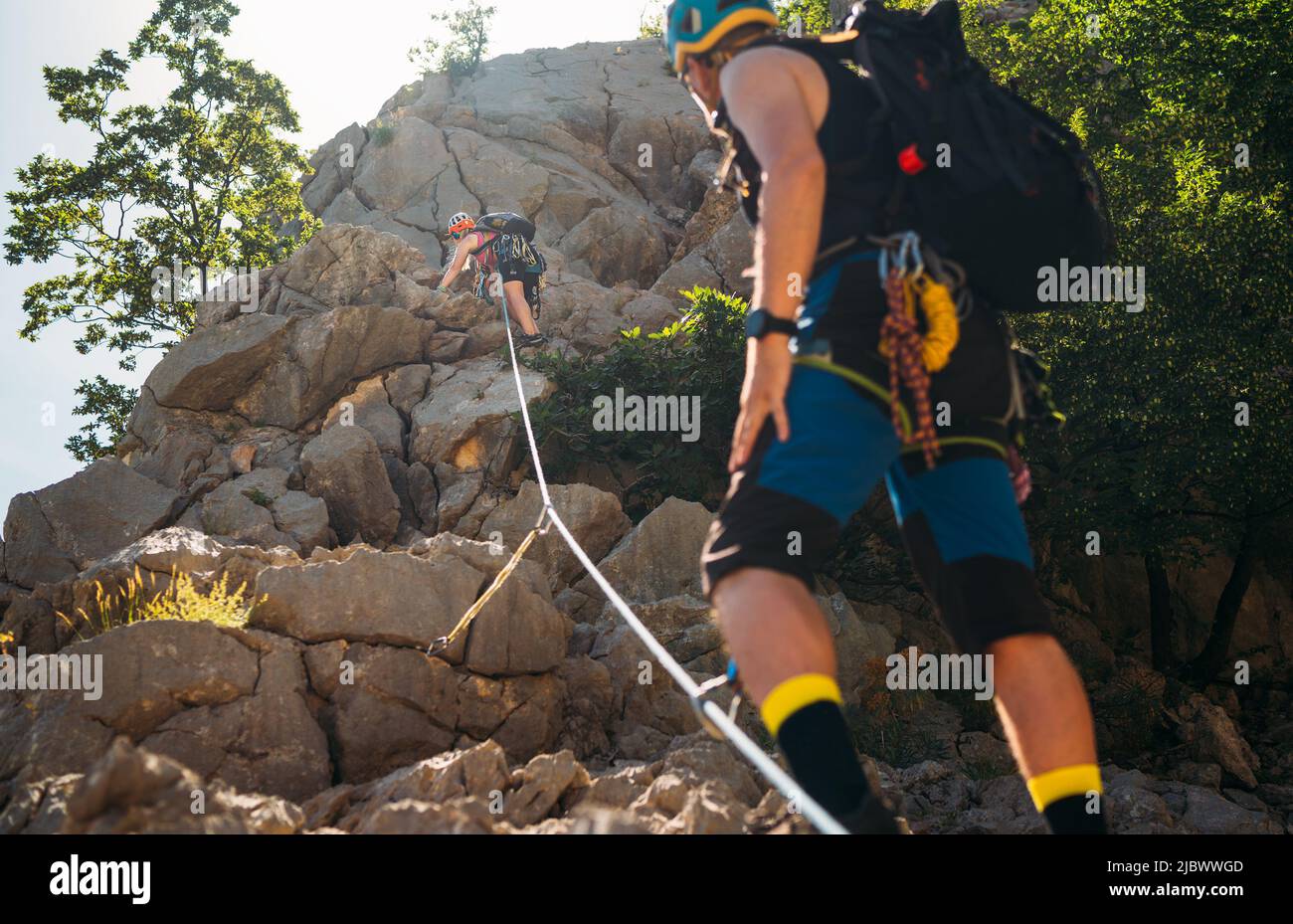 Kletterer Frau und Mann in Schutzhelmen und Klettergurten aufsteigende Klippen an der Felswand im Nationalpark Paklenica in Kroatien. Aktiv e Stockfoto