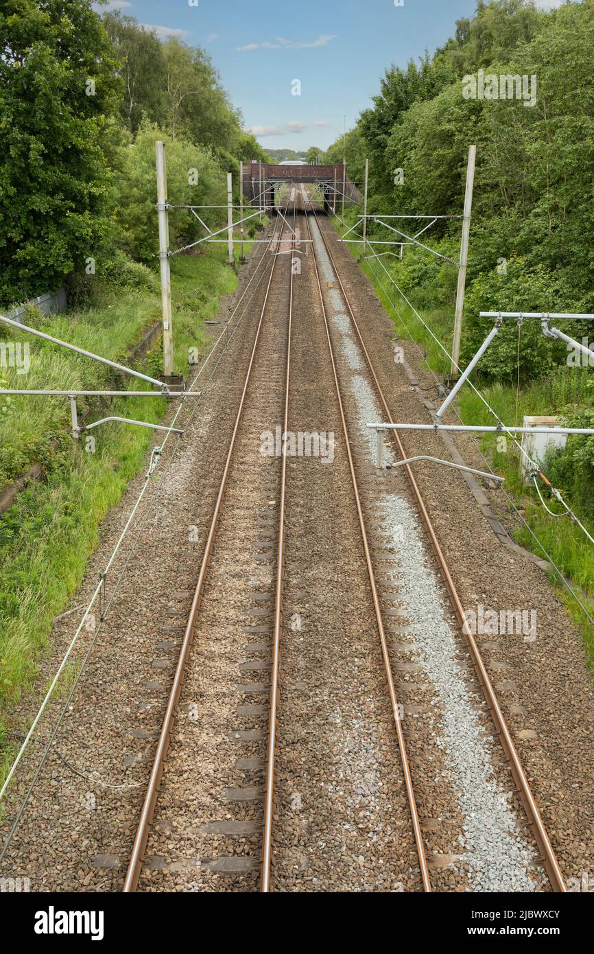 Die Gleise fahren in die Entfernung, in der die Oberleitung von oben in der Vertikalen aufgenommen wurde Stockfoto