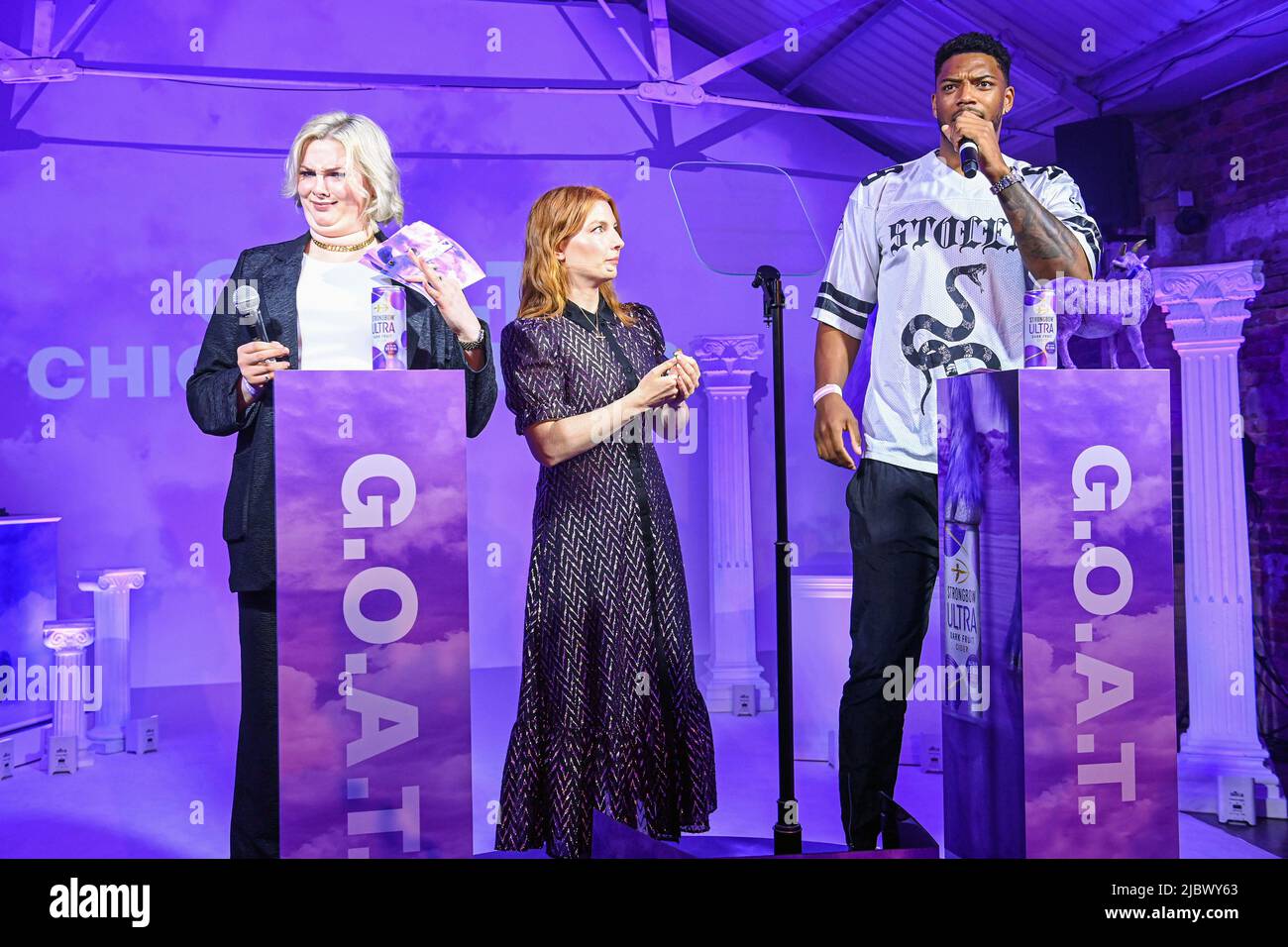 NUR FÜR REDAKTIONELLE VERWENDUNG Moderatorin Alice Levine (Mitte) auf der Bühne mit Rachel Spicer (links) und Theo Campbell (rechts), die beim Strongbow Ultra Greatest of All Time Award in Shoreditch, London, den G.O.A.T Award für den besten Hühnerstall debattieren. Bilddatum: Mittwoch, 8. Juni 2022. Das von der Cider-Marke moderierte Event, bei dem Reality-TV-Stars, Drag Queens, Musiker und Social-Media-Influencer zu Gast waren, wurde von der Sendeanstalt und der weltbekannten Podcasterin Alice Levine moderiert. Bildnachweis sollte lauten: Matt Crossick/PA Stockfoto