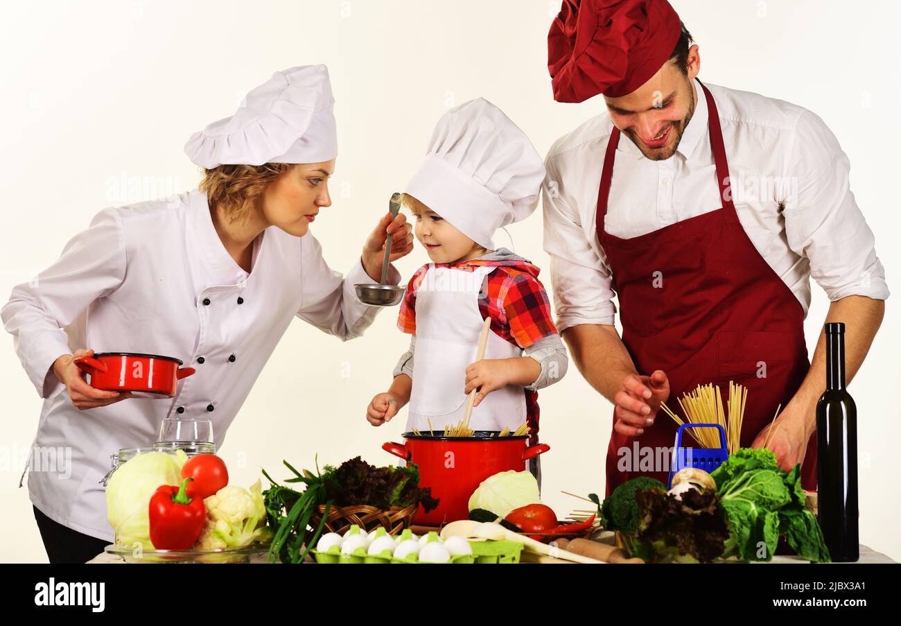 Mutter, Vater und Sohn bereiten schmackhaftes Essen in der Küche zu. Gemeinsam kochen. Gesunde Mahlzeit. Stockfoto