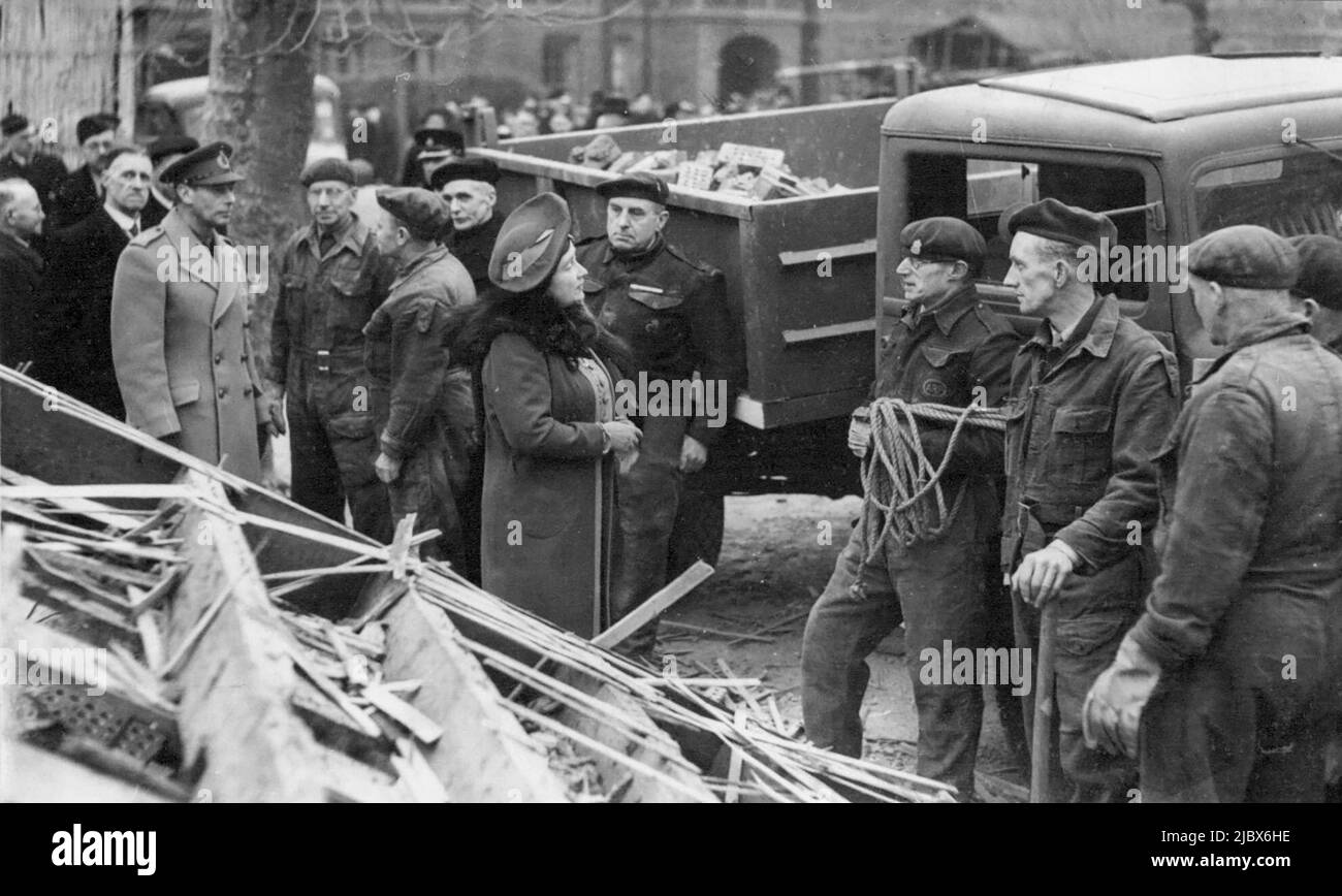 König und Königin sehen Londoner Bombenschaden - ihre Majestäten sprechen mit Rettungskräften des Zivilschutzes, die immer noch in einer Londoner Straße graben, um Menschen zu finden, die während ihrer Tour durch bombardierte Gebiete am 25. Februar begraben wurden. Innerhalb weniger Stunden nach dem sechsten Versuch der Luftwaffe, London zu feuern, machten der König und die Königin gestern eine Tour durch die bombardierten Gebiete. Nach dem Besuch eines Erholungszentrums in einem Bezirk, das zu den schlimmsten Erkrankten der letzten Razzien gehört. 23. Februar 1944. (Foto von Associated Press Photo). Stockfoto