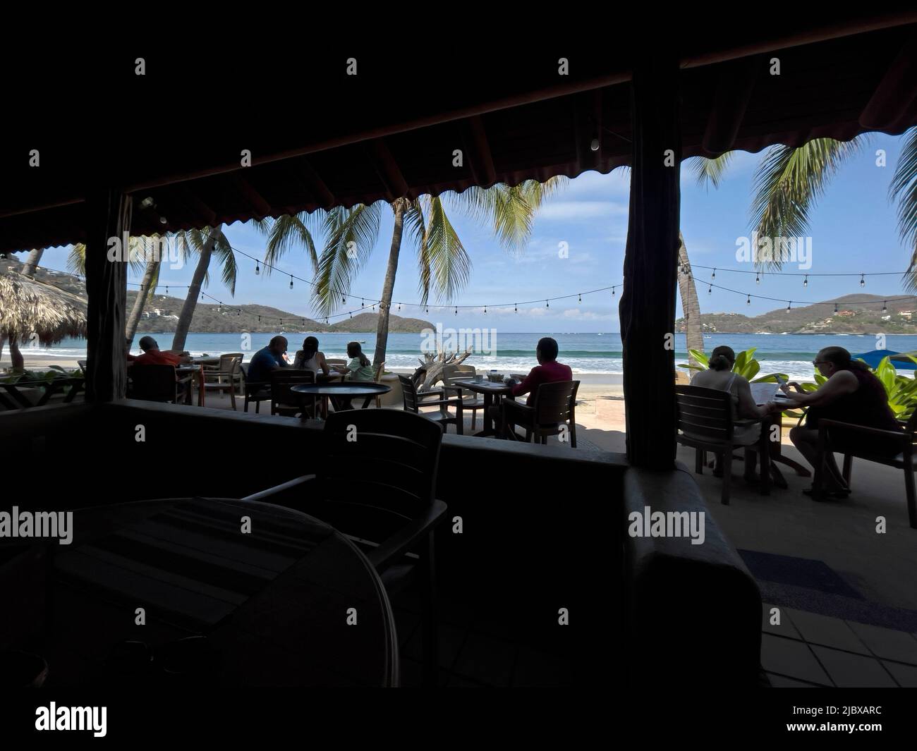 Abendessen im Restaurant im Freien am Strand von La Playa Ropa in Zihuatanejo, Mexiko Stockfoto