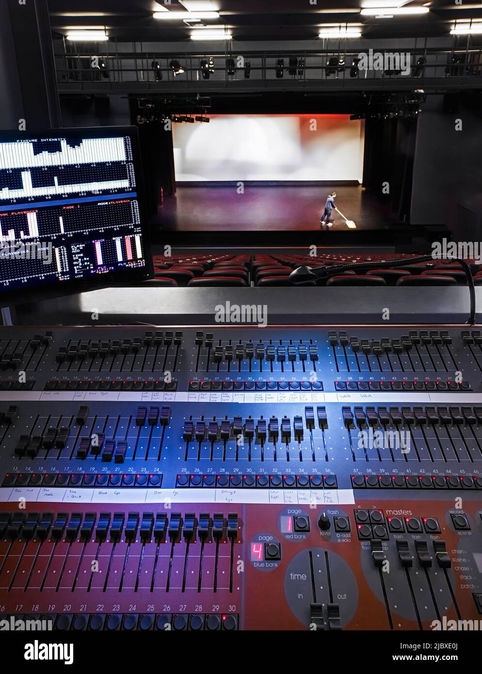 Blick vom Bedienfeld auf Ton und Beleuchtung hin zu einer Person, die die Bühne im Theater fegen kann Stockfoto