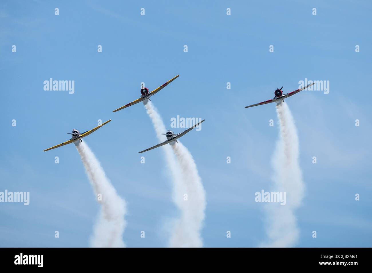 Reading, Pennsylvania, USA-6. Juni 2022: Vier Flugzeuge aus dem Zweiten Weltkrieg, die Rauch nachlassen, fliegen während des Mittleren Atlantischen Museums-Weltkrieges vor blauem Himmel vorbei Stockfoto