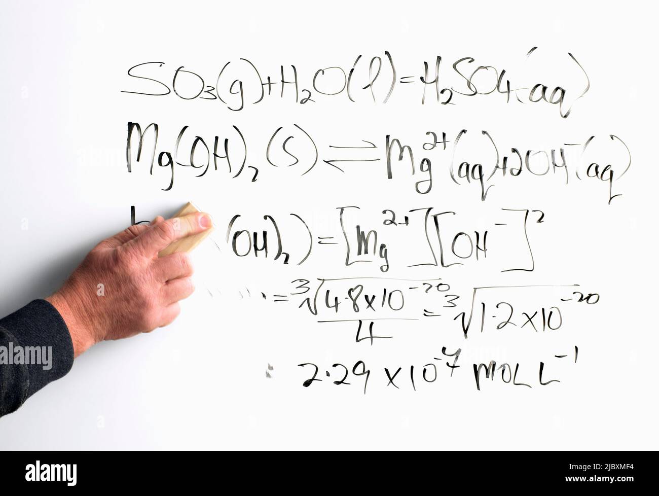 Mans Hand reibt mathematische Gleichung aus dem Whiteboard Stockfoto