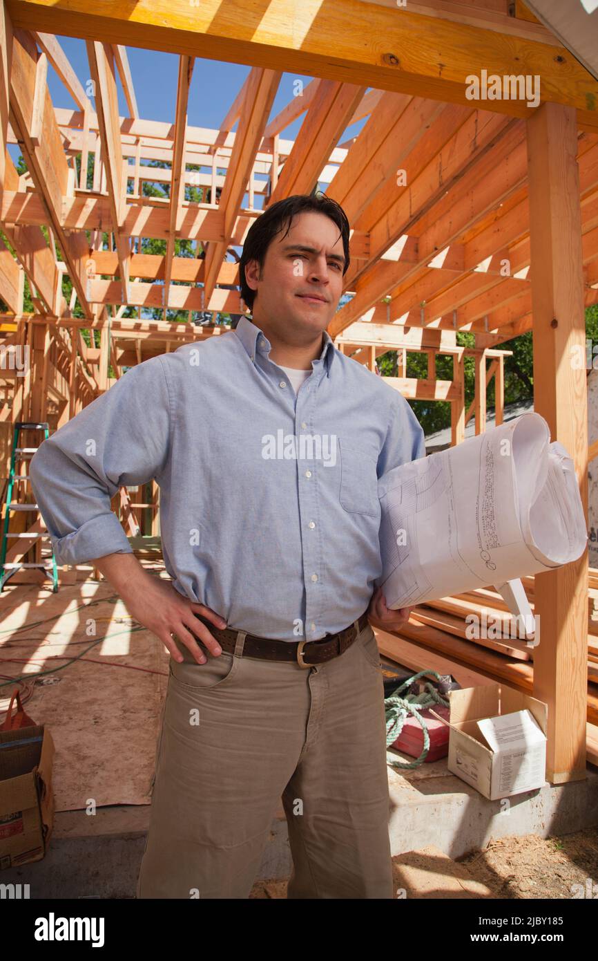 Auftragnehmer, der Pläne auf der Wohnbaustelle hält Stockfoto