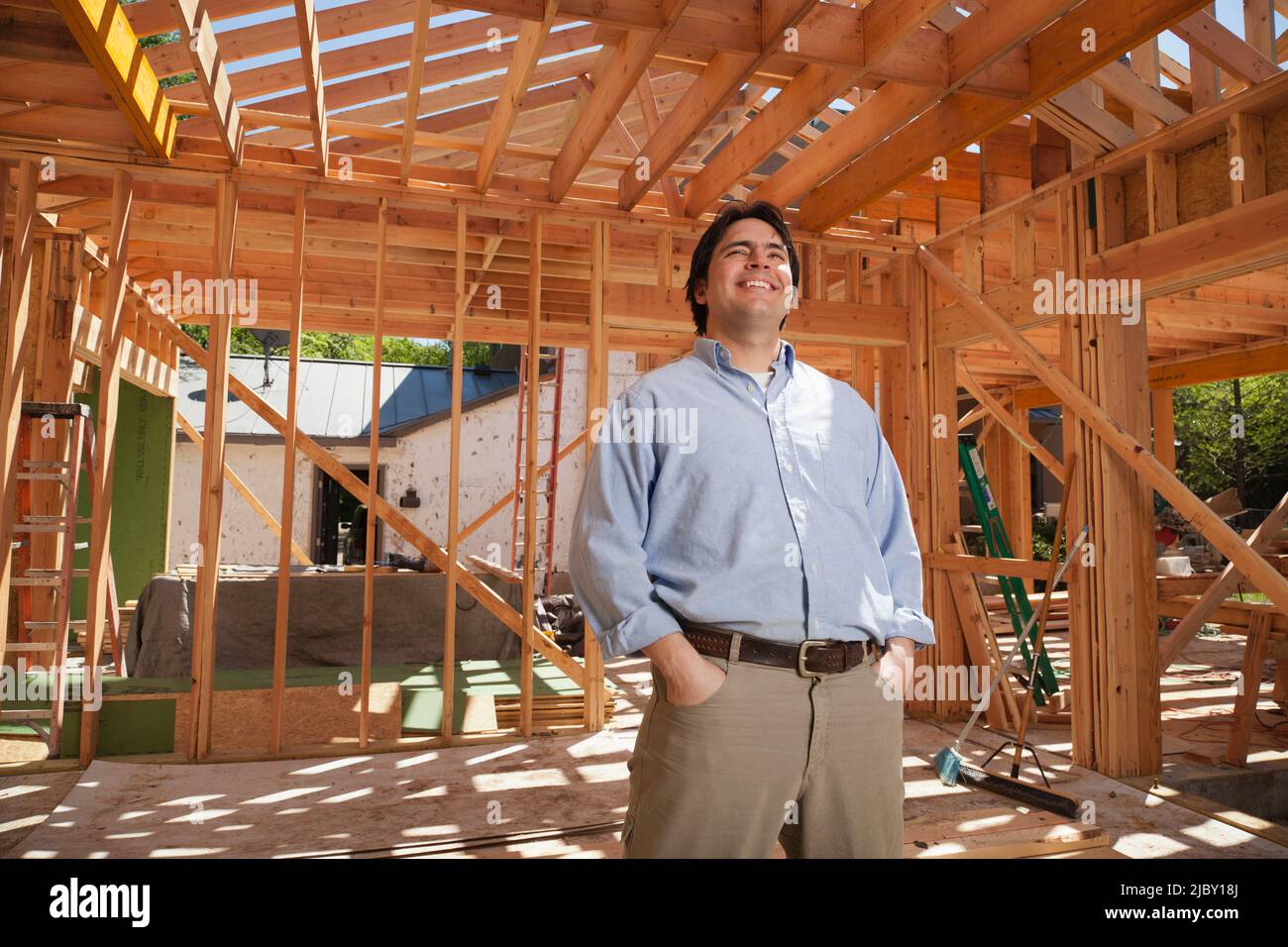 Mann mit Händen in den Taschen, der auf einer Wohnbaustelle steht Stockfoto
