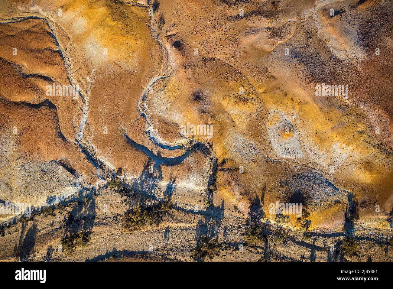 Vogelperspektive auf die australische, öde Landschaft aus der Mitte Südaustraliens. Luftaufnahmen über der Painted Desert, Dry Creek Beds und Buschland Stockfoto
