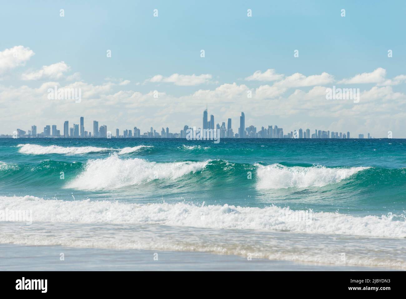 Blick über die Wellen am Kirra Beach zur Skyline von Surfers Paradise Stockfoto