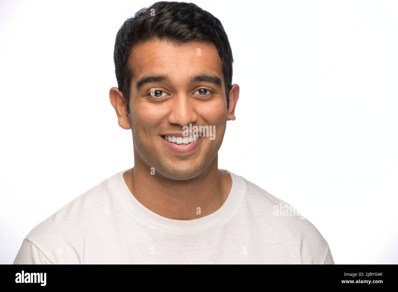 Porträt eines jungen indischen Mannes, der mit einem Lächeln auf die Kamera blickt Stockfoto