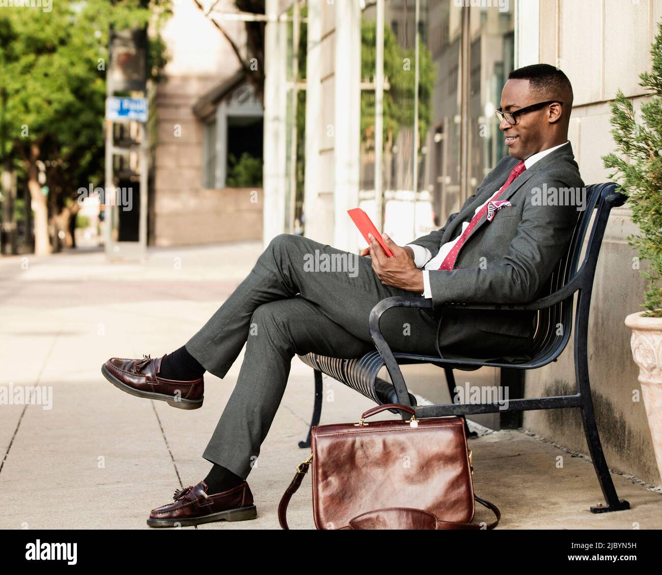 Schwarze Geschäftsmann mit digital-Tablette auf Bank Stockfoto