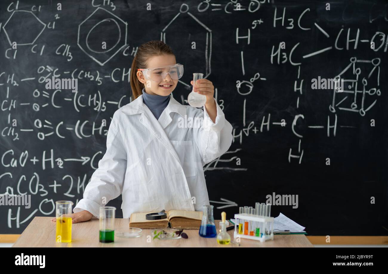 Experimente in einem Chemielabor. Ernsthafte kleine Studentin, die ein Experiment im Labor durchführt. Mädchen macht ein chemisches Experiment am Unterricht Stockfoto