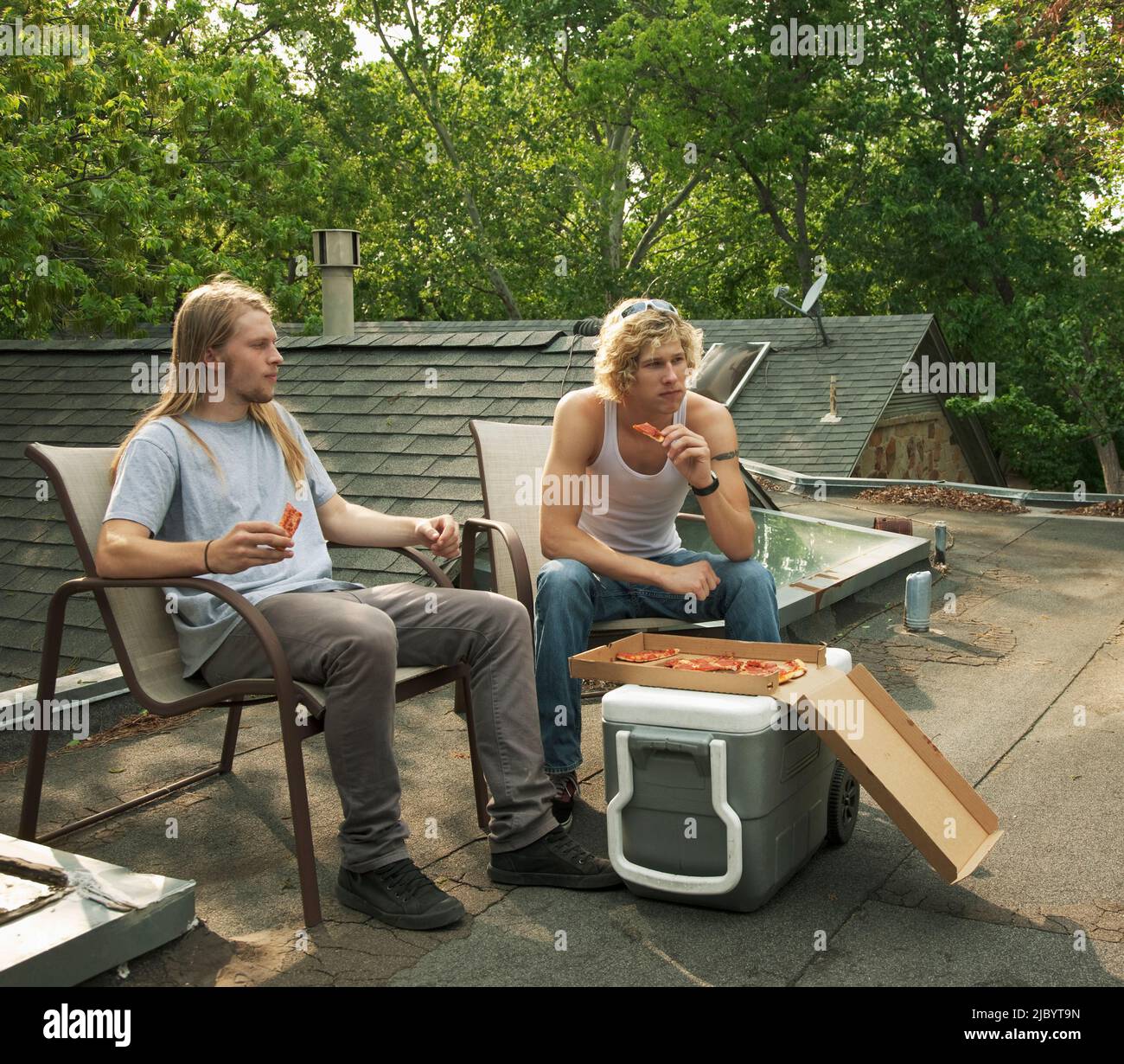 Freunde, die gemeinsam essen Pizza auf Dach Stockfoto