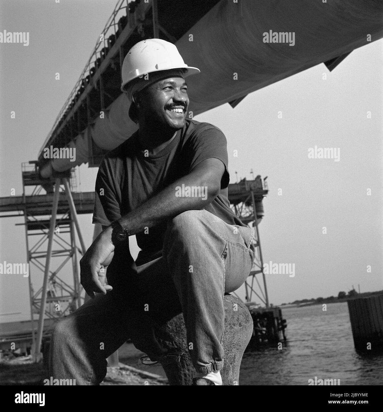 Afrikanische amerikanische männliche Schweißer neben Wasser Stockfoto