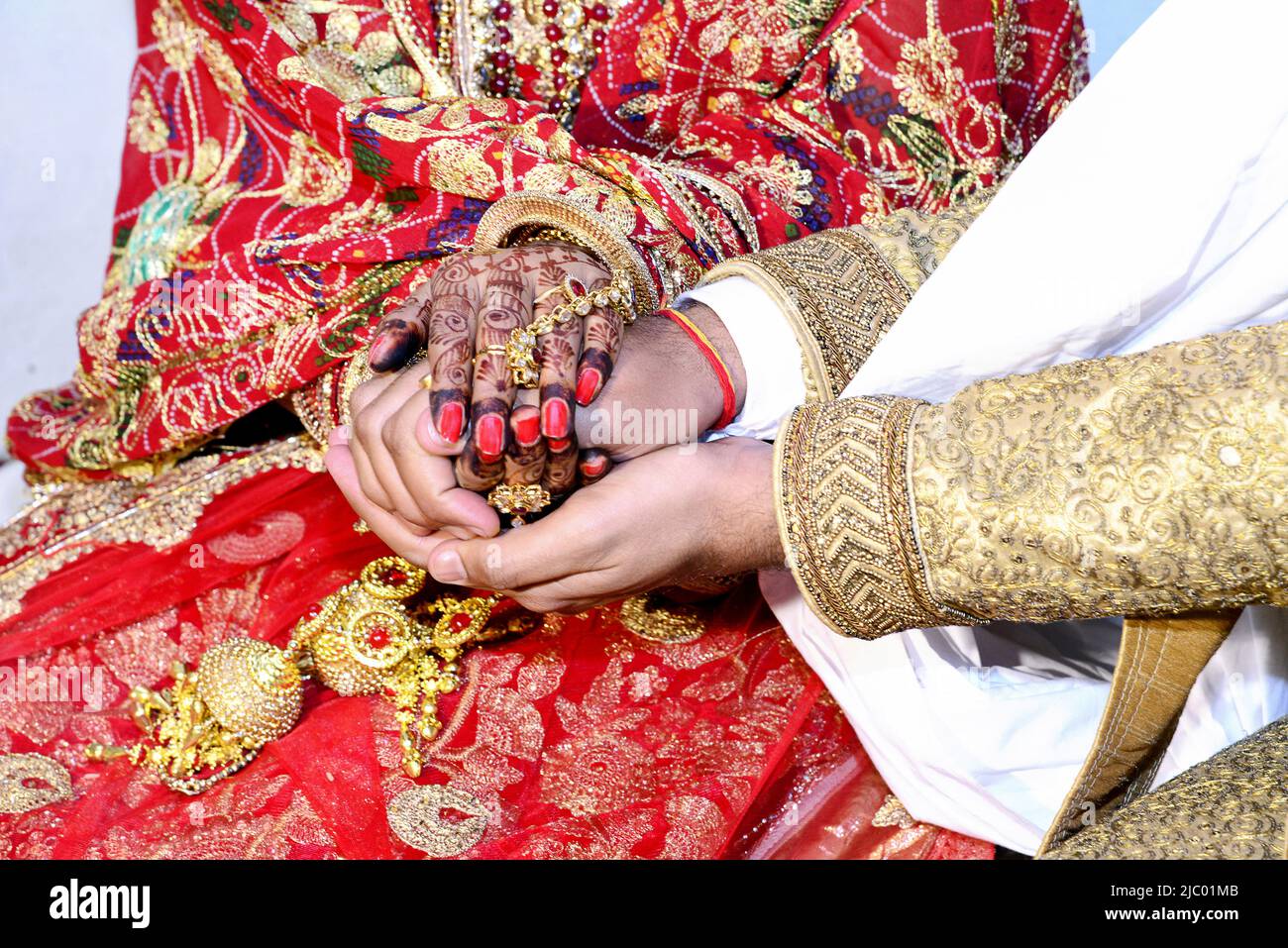 Die Hand einer indischen Braut und eines indischen Bräutigams wird vor den Hochzeitsritualen zusammengebunden Stockfoto