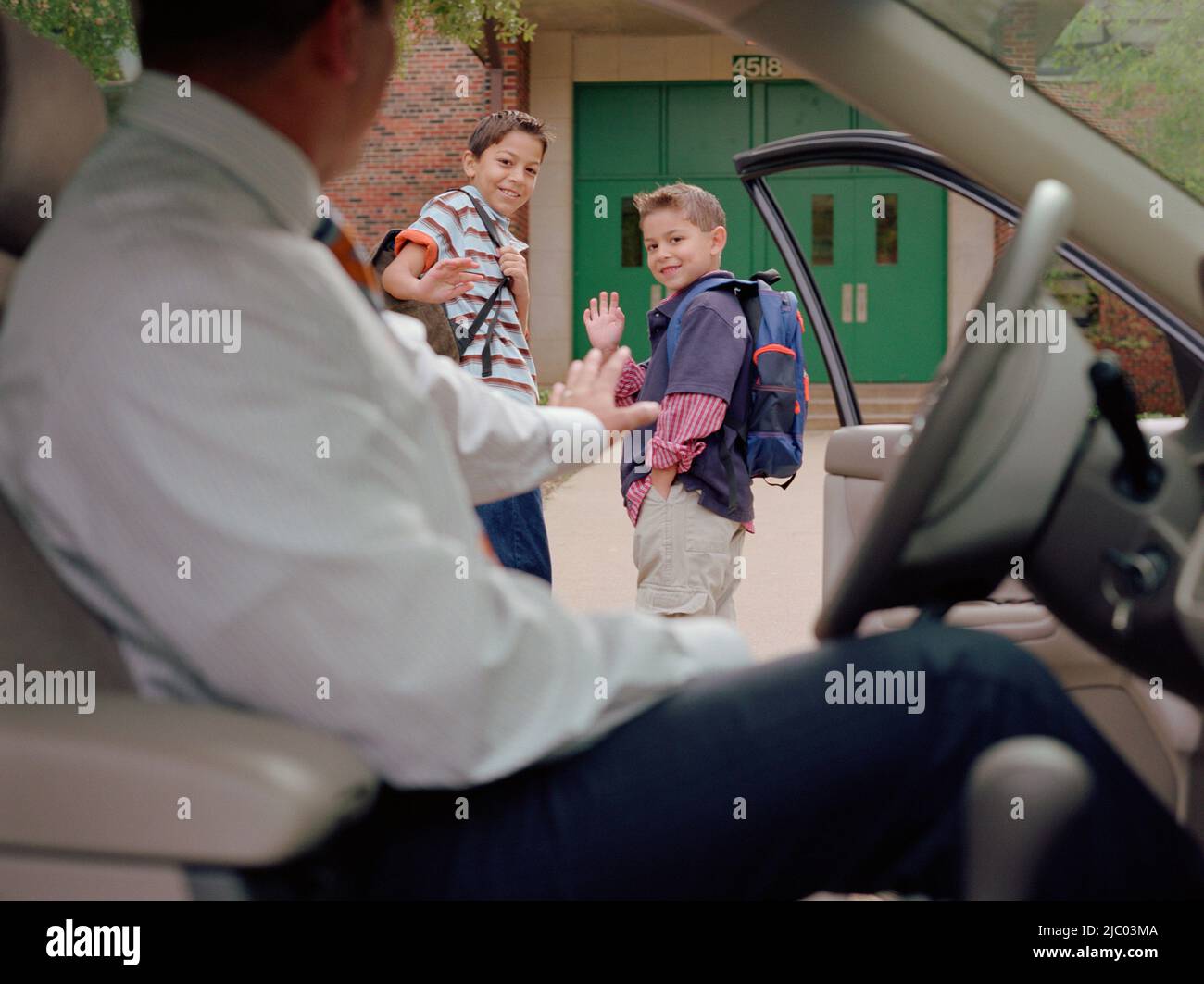 Junger Mann schwenkte seine Söhne Weg zur Schule Stockfoto