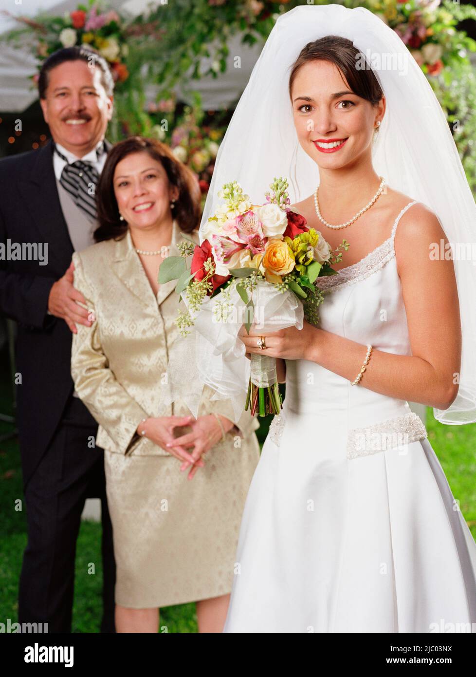 Braut posiert für die Kamera mit ihren Eltern Stockfoto