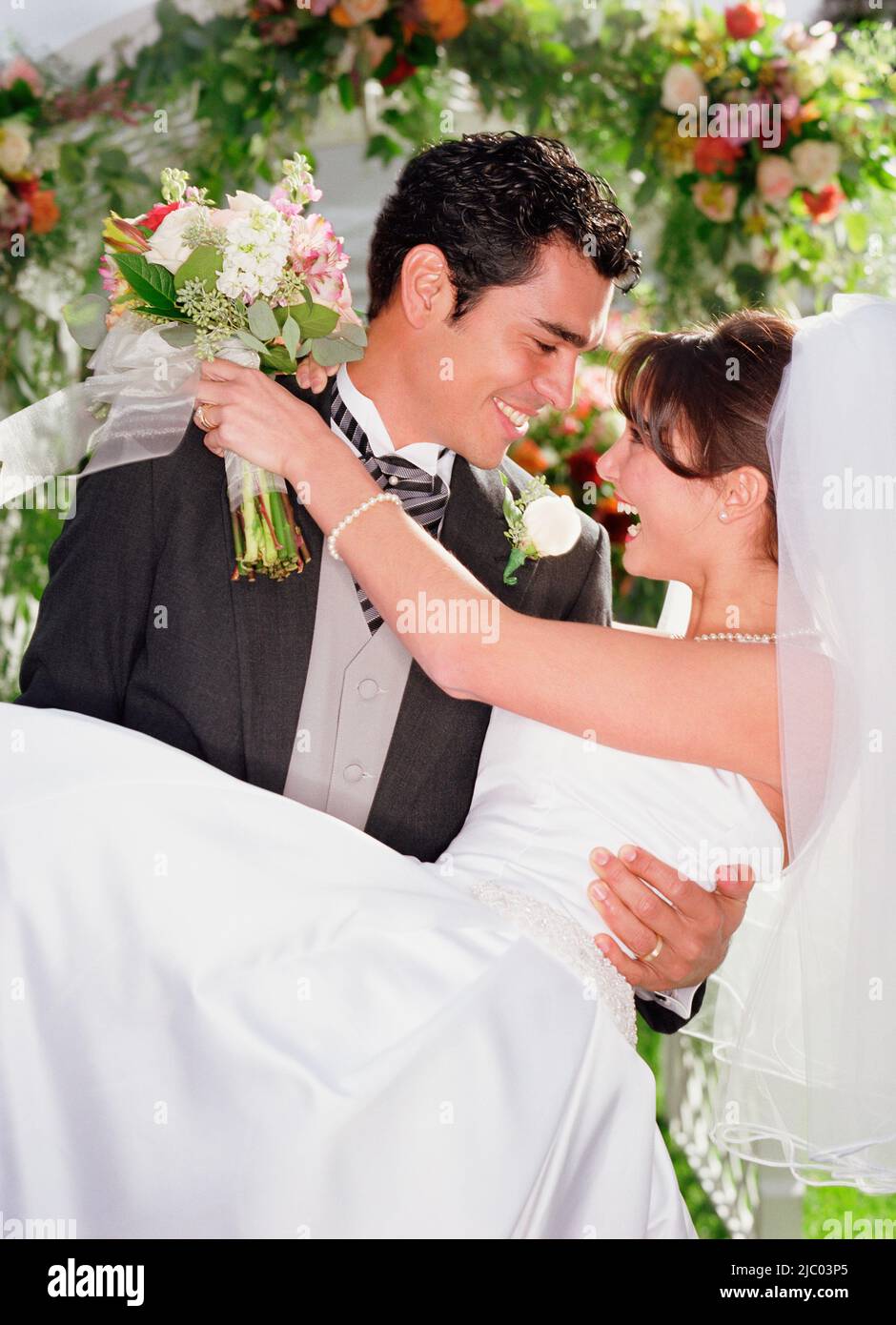 Bräutigam seine Braut in seinen Armen zu halten Stockfoto